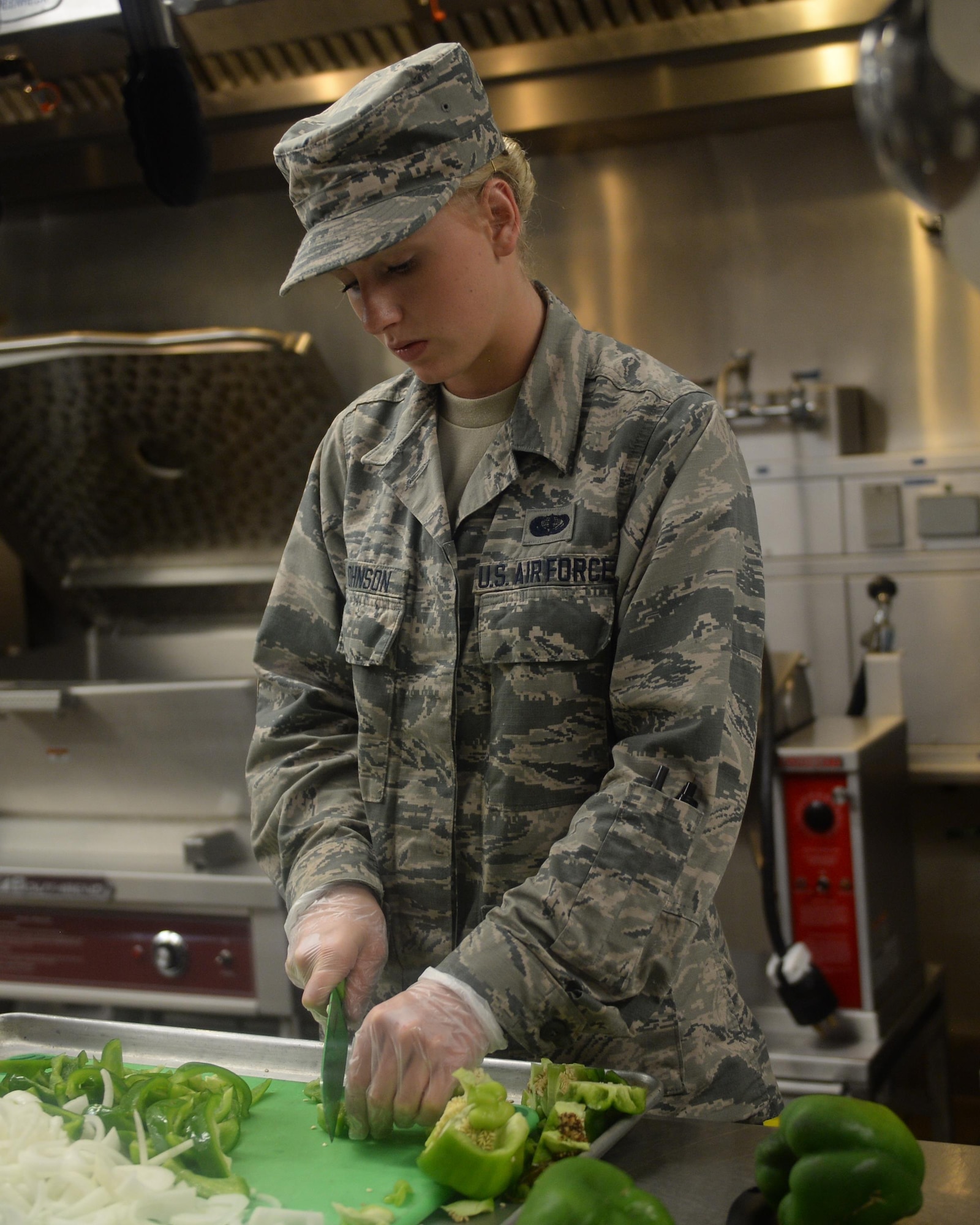 Airman Basic Carli Johnson, 325th Force Support Squadron Berg-Liles Dining Facility chef, chops bell peppers in preparation for a meal at Tyndall Air Force Base, May 17. Food service specialist like Johnson are trained to be knowledgeable in functions such as preparing, cooking, baking, presenting, and serving food. (U.S. Air Force photo by Airman 1st Class Cody R. Miller/Released)