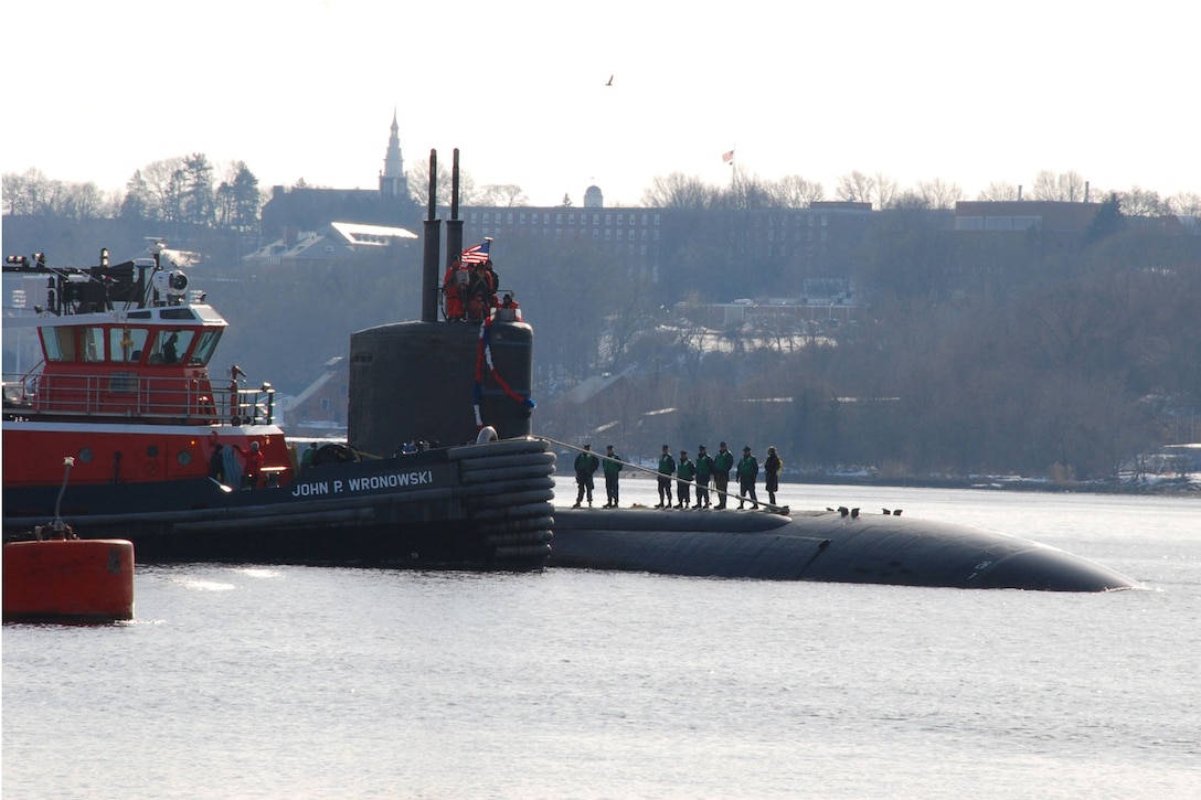 A tug boat helps guide the Los Angeles-class submarine USS Toledo through the Thames River to Naval Submarine Base New London, Conn., following a regularly scheduled deployment, Jan. 20, 2011. Defense Secretary Ash Carter will visit the submarine base during his May 23-25 visit to New England. Navy photograph by Petty Officer 1st Class Virginia K. Schaefer