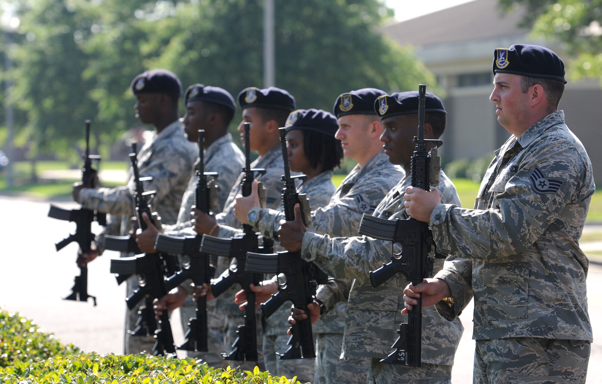 Members of the 81st Security Forces Squadron 3-volley rifle salute team stand at attention with their weapons during the 81st SFS Retreat Ceremony May 19, 2016, Keesler Air Force Base, Miss. The ceremony was held during National Police Week, which recognizes the service of law enforcement men and women who put their lives at risk every day. (U.S. Air Force photo by Kemberly Groue)