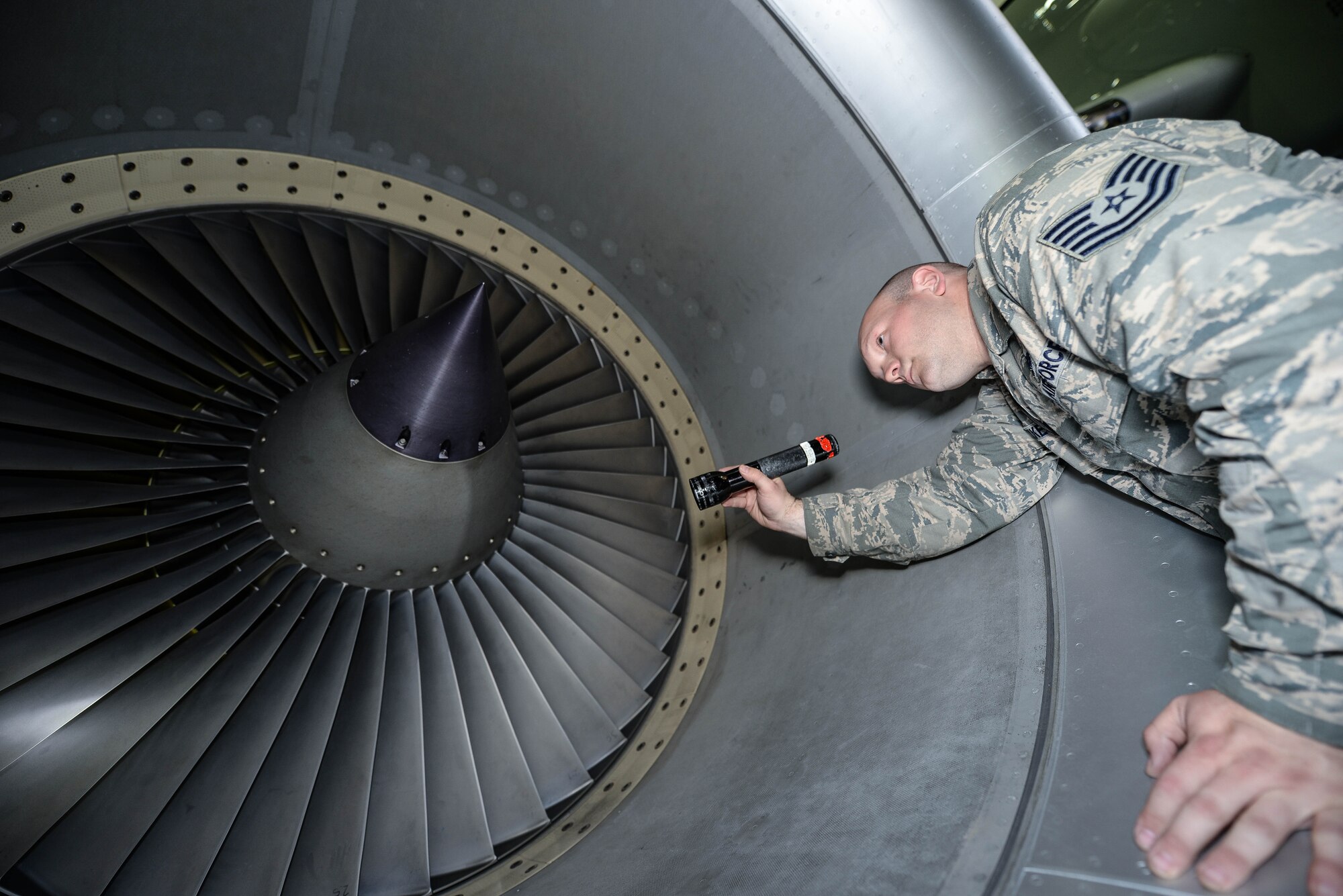 U.S. Air Force Tech. Sgt. Aaron Wilkes, 55th Aircraft Maintenance Squadron dedicated crew chief, inspects the fan blades of a RC-135 Rivet Joint April 24 in the Bennie Davis Maintenance Facility on Offutt Air Force Base, Nebraska. Wilkes is part of the 83rd Aircraft Maintenance Unit. (U.S. Air Force photo by Zachary Hada)