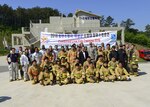 Firefighters from the 51st Civil Engineer Squadron fire and emergency services flight pose with members of the Songtan fire department at the Kyonggi-do Fire Academy, Republic of Korea, May 18, 2016. The firefighters prepared for a live fire training exercise at the fire academy. 