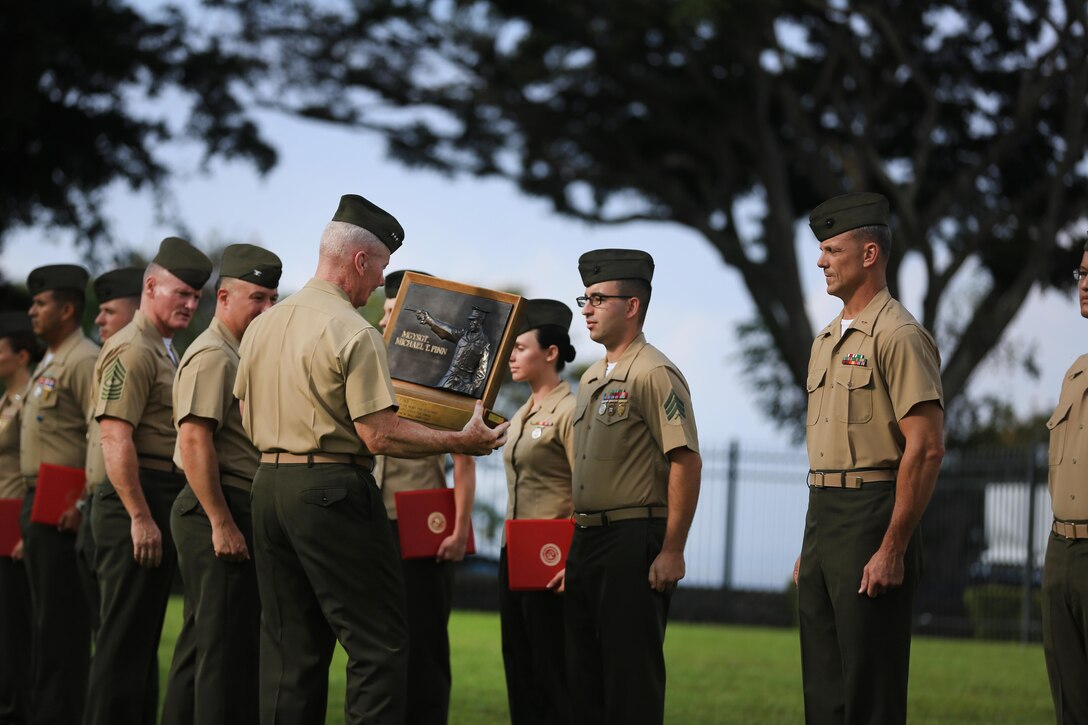 Lt. Gen. John A. Toolan, commander, U.S. Marine Corps Forces, Pacific, presents the Master Gunnery Sgt. Michael T. Finn Trophy to the MARFORPAC shooting team during a battalion formation on Camp H.M. Smith, Hawaii, May 6, 2016. The formation was held to award the Marines of MARFORPAC a Meritorious Unit Commendation, the shooting team the Master Gunnery Sgt. Michael T. Finn trophy for winning the Pacific Division pistol matches, and the MARFORPAC Band the U.S. Marine Corps Band of the Year trophy. 