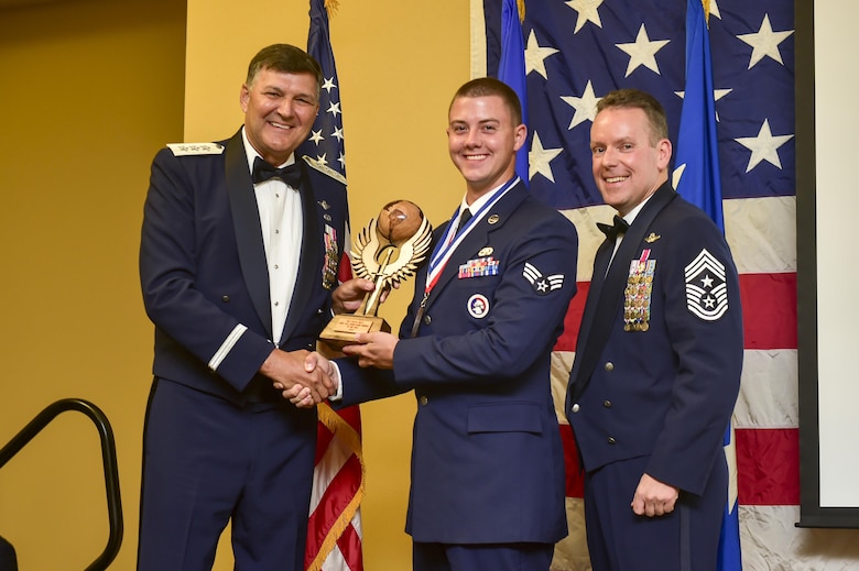 Air Force Special Operations Command Commander Lt. Gen. Brad Heithold presents the honor guard member of the year trophy to Senior Airman Travis Boley, 1st Special Operations Force Support Squadron, with Chief Master Sgt. Cory Olson during the banquet at Hurlburt Field, May 19, 2016. (U.S. Air Force photo by Senior Airman Jeff Parkinson)