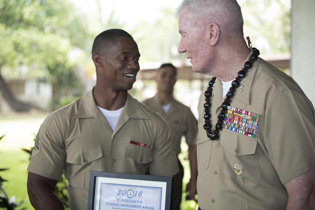 U.S. Marine Corps Forces, Pacific Commander, Lt. Gen. John A. Toolan, congratulates Sgt. David Wilson for receiving the Clerical and Assistant Employee of the Year award, during the Annual Excellence in Federal Government Awards Ceremony celebrated at the Hickam Officer's Club at Joint Base Pearl Harbor-Hickam, Hawaii, May 6, 2016. Wilson works with the G-1 section at MARFORPAC. The Annual Excellence in Federal Government Award program is known as an important form of recognition for federal employees in the Honolulu-Pacific area.