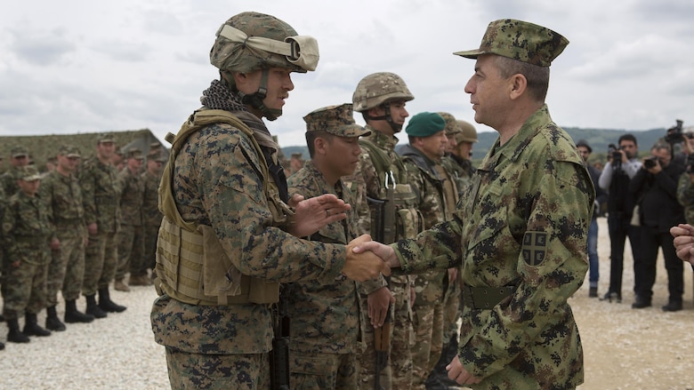 Lt. Gen. Jovica Draganic, Deputy Chief of Staff of the Army of Serbia,(right) presents a coin to Sgt. Ty Heaps, platoon sergeant for 1st platoon, 4th Law Enforcement Battalion, Force Headquarters Group, Marine Forces Reserve, in appreciation of his hard work and efforts during exercise Platinum Wolf 2016 at Peacekeeping Operations Training Center South Base, Bujanovac, Serbia, May 20, 2016. The nations of Bosnia, Bulgaria, Macedonia, Montenegro, Slovenia, Serbia and the United States joined together during the final field exercises to demonstrate their abilities to conduct peacekeeping operations and the ability to work together.