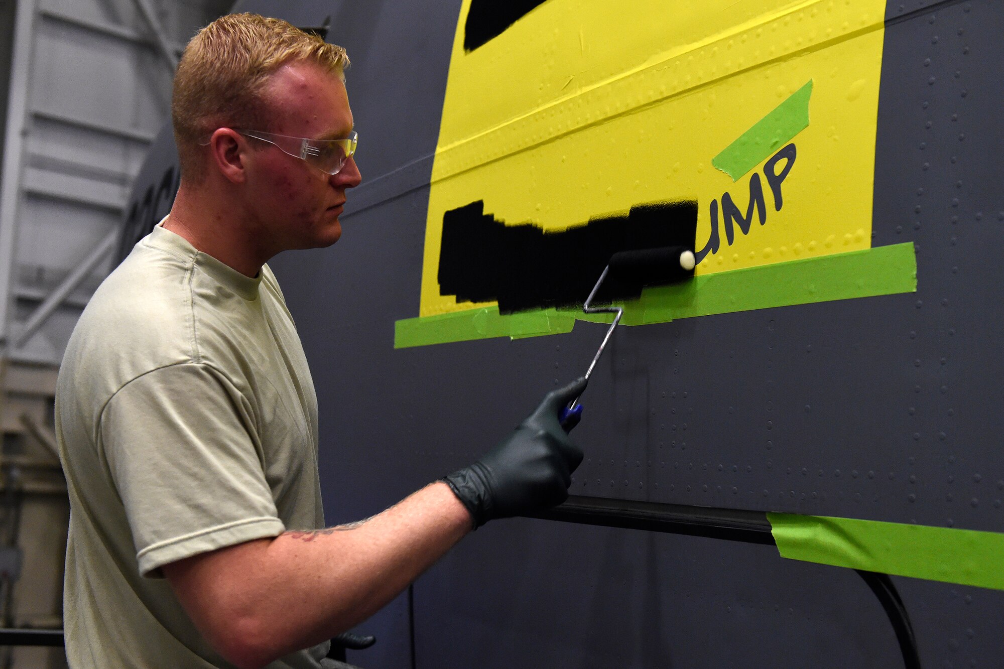 SrA Brandon Breshears, 62nd Maintenace Squadron structural maintenance mechanic, applies a stencil to a 62nd Airlift Wing C-17 Globemaster III for the naming of the aircraft May 12, 2016 at Joint Base Lewis-McChord, Wash. The name, “The Spirit of the Hump” comes from the airlift missions, known as flying the hump, that were flown over the Himalayan Mountains between India and China from 1943 to 1945 involving U.S. C-46 Commandos and C-47 Skytrains. (U.S. Air Force photo/Tech. Sgt. Tim Chacon) 