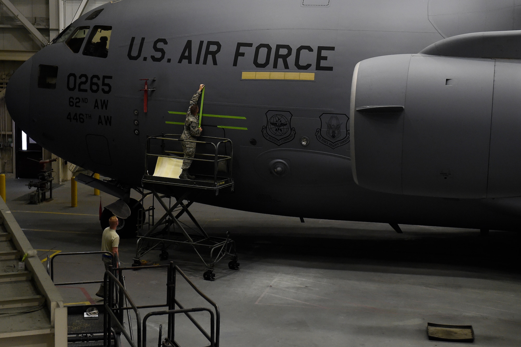 Airmen from the 62nd Maintenance Squadron apply a stencil to a 62nd Airlift Wing C-17 Globemaster III for the naming of the aircraft May 12, 2016 at Joint Base Lewis-McChord, Wash.” The name, “The Spirit of the Hump” comes from the airlift missions, known as flying the hump, that were flown over the Himalayan Mountains between India and China from 1943 to 1945 involving U.S. C-46 Commandos and C-47 Skytrains. As it is extremely rare for a C-17 to be named, this marks the 4th aircraft out of 48 assigned C-17s at McChord Filed to receive this honor. (U.S. Air Force photo/Tech. Sgt. Tim Chacon) 