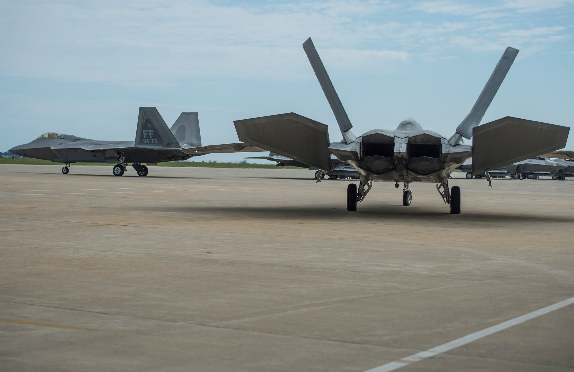 U.S. Air Force F-22 Raptors taxi to the end of the runway at Langley Air Force Base, Va., May 19, 2016. The 94th Fighter Squadron launched 12 Raptors to participate in Red Flag-Alaska, an exercise designed to replicate the stresses that warfighters must face during their combat sorties. (U.S. Air Force photo by Senior Airman Kayla Newman)
