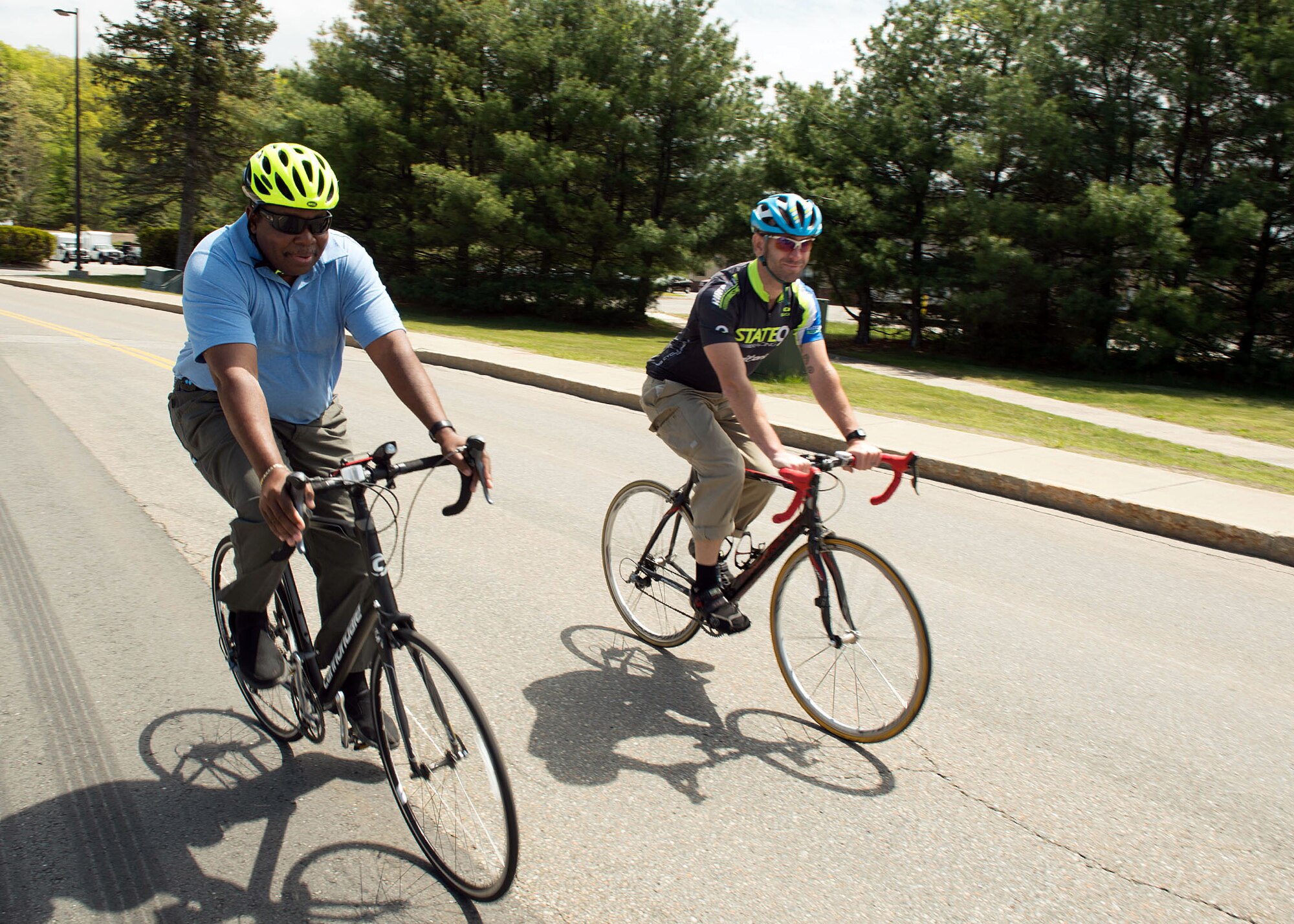 O’Neill Mazyck, right, 66th Civil Engineering Division hazardous material manager, and Andy Gould, National Response Corporation environmental chemist, ride bicycles on base May 19 as part of Bay State Bike Week. Personnel assigned to Hanscom Air Force Base, Mass., and MIT Lincoln Laboratory, partnered with the Massachusetts Department of Transportation to celebrate the 22nd anniversary of Bay State Bike Week, May 14 through 22. (U.S. Air Force photo by Jerry Saslav)