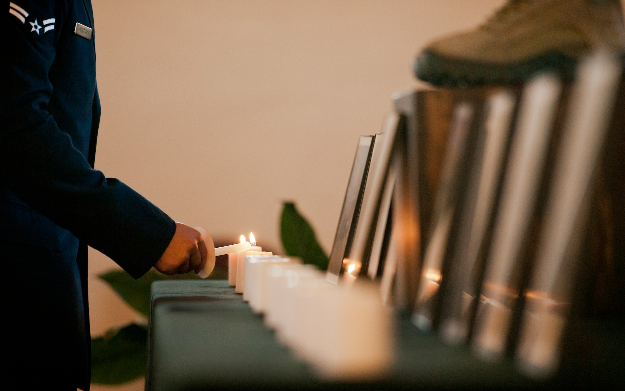 An Airman lights a candle in front of a photo of a fallen security forces defender during a candle light vigil May 19 at Eglin Air Force Base, Fla.  The ceremony was held to honor the fallen police, defenders and agents from the previous year during National Police Week.  Nine candles were lit in remembrance including one for Okaloosa County Sheriff’s Deputy Bill Myers and Special Agent Adrianna Vorderbruggen.  (U.S. Air Force photo/Samuel King Jr.)