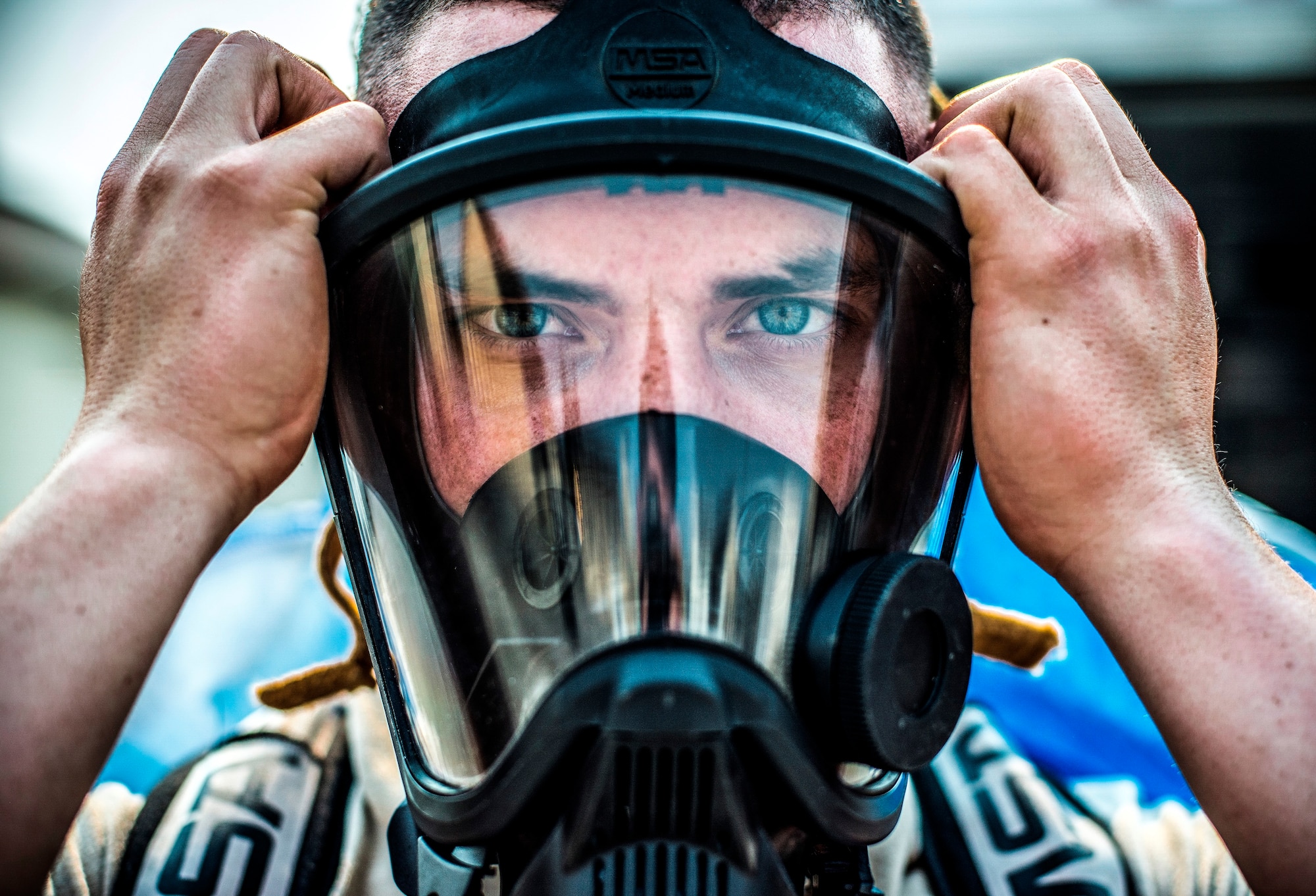 U.S. Air Force Airman 1st Class Petri Brand, a bioenvironmental engineering journeyman with the 35th Aerospace Medicine Squadron, tightens his mask at Misawa Air Base, Japan, May 19, 2016. Brand suited up in a chemical protective suit to show the extent of their work when a chemical is present in the area. Bioenvironmental engineering specialists focus on reducing health hazards in the workplace and the surrounding areas to ensure mission success. (U.S. Air Force photo by Senior Airman Brittany A. Chase)