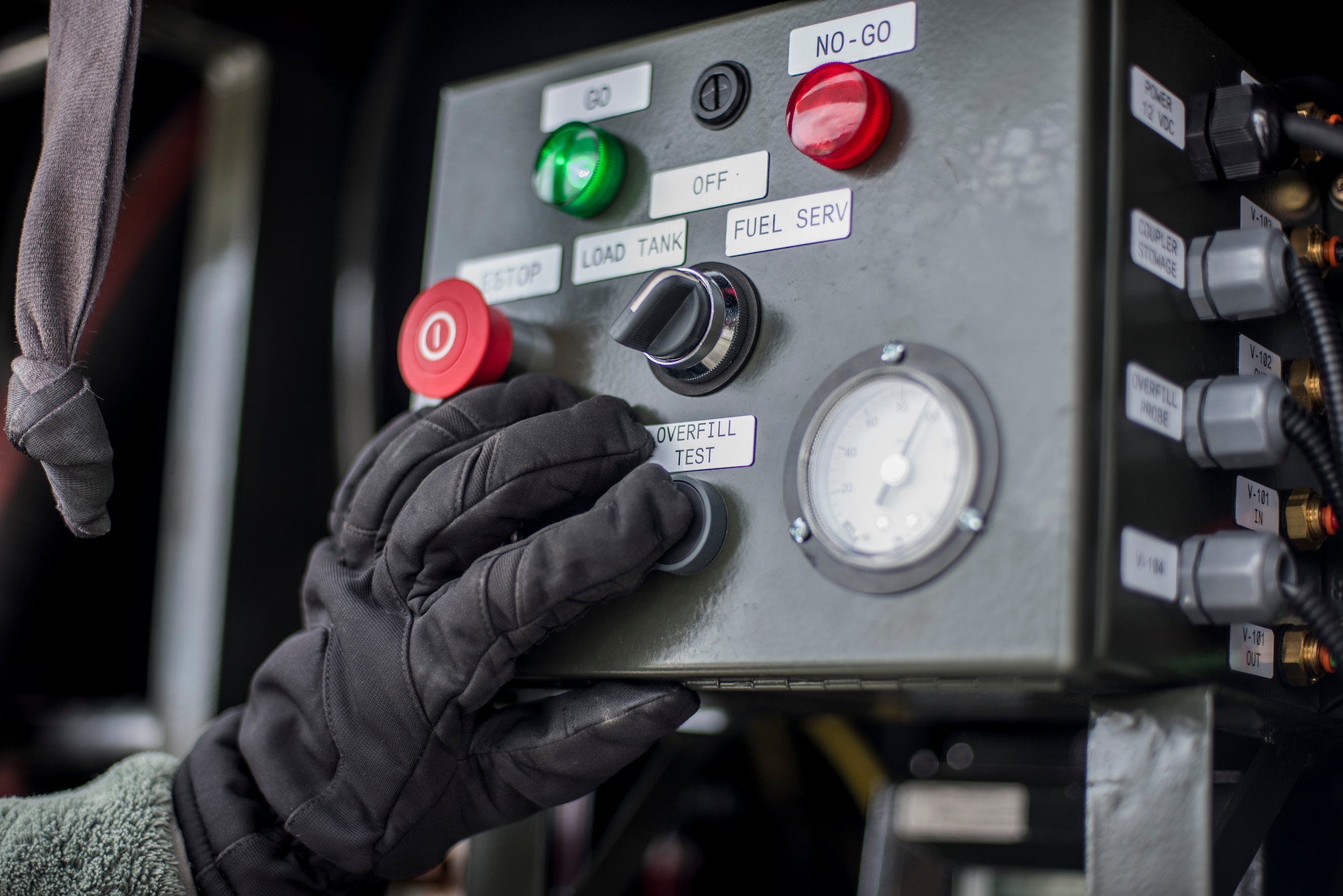 U.S. Air Force Senior Airman Joel Burger, a fuel distribution technician with the 35th Logistics Readiness Squadron, pushes an overfill test button at Misawa Air Base, Japan, March 22, 2016. Burger was monitoring fuel pressures and flow rates during a Hydrant Mobile Refueler procedure. (U.S. Air Force photo by Senior Airman Brittany A. Chase)