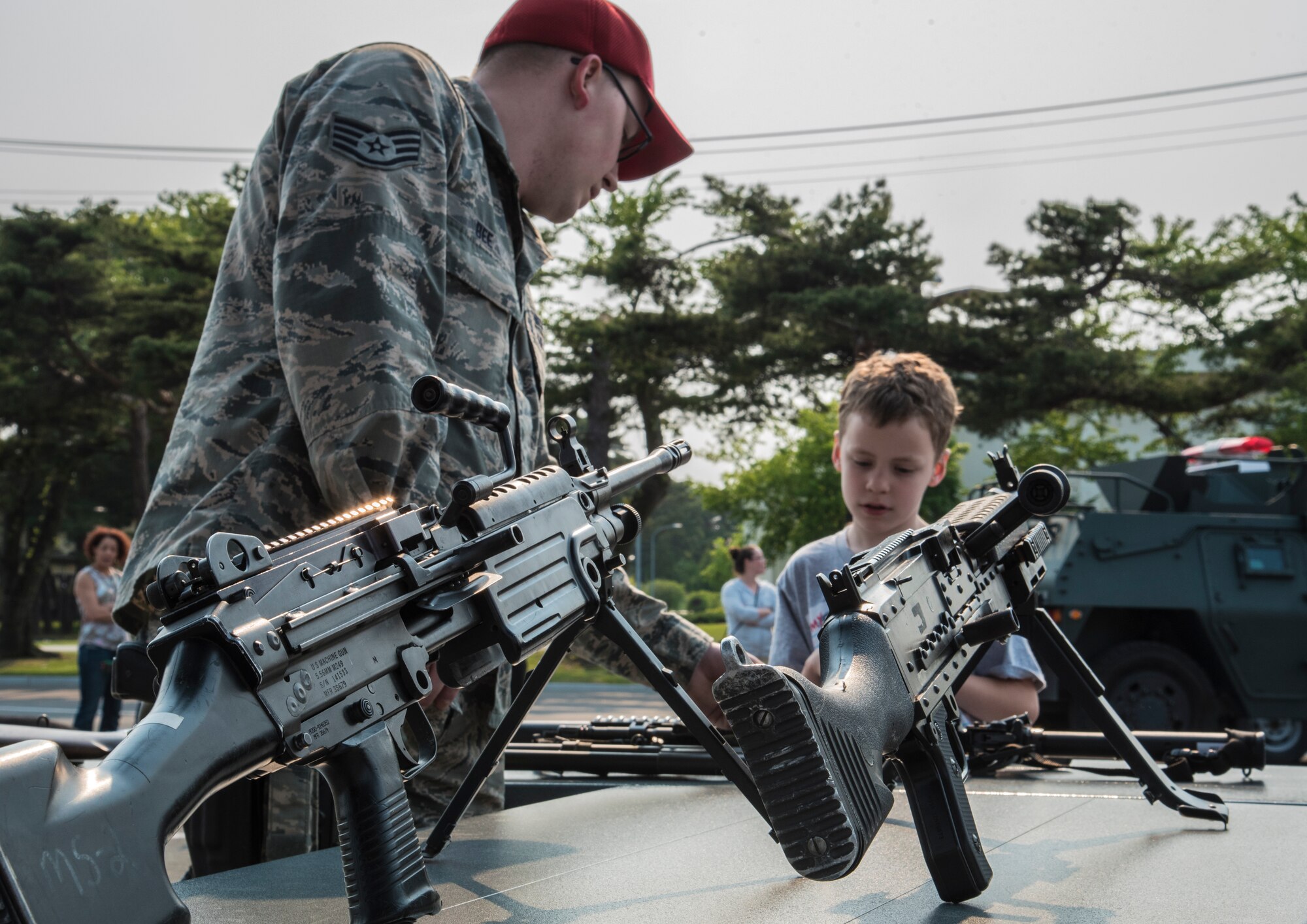 U.S. Air Force Staff Sgt. Tyler Bee, a senior force protector with the 35th Security Forces Squadron, explains the mechanics of an M-240 B machine gun and an M-249 automatic rifle to participants of Police Week at Misawa Air Base, Japan, May 19, 2015. In 1962, President John F. Kennedy signed a proclamation designating the week in which May 15, Peace Officers Memorial Day, falls under as Police Week. (U.S. Air Force photo by Airman 1st Class Jordyn Fetter)