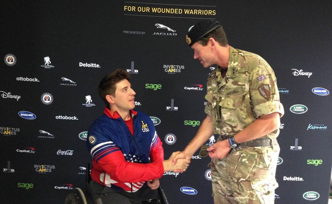 Maj. Gen. Neil Marshall, Senior British Military Advisor, U.S. Central Command receives a combat patch from U.S. Army Staff Sgt. (Ret.) Timothy Payne at this year’s Invictus Games. The patch was worn by Payne on the day he was injured by an improvised explosive device in 2011 near Kandahar, Afghanistan. 