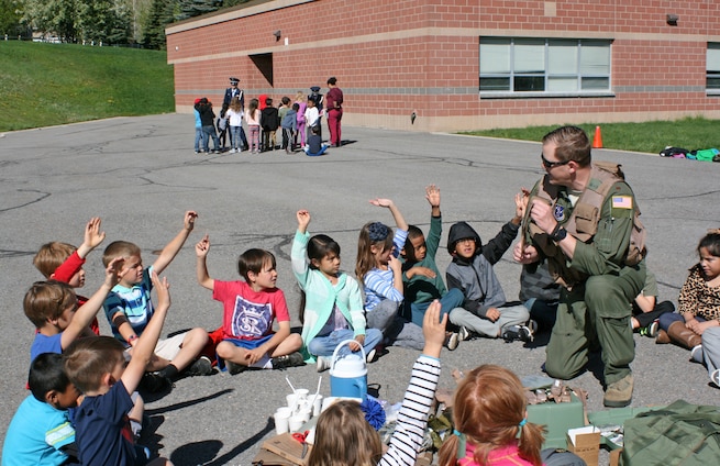 Air Force Maj. TJ Eaton, a pilot with the 151st Operations Group, visits a
local elementary school on May 18 in honor of Armed Forces Day. Eaton showed
a group of more than 50 children various Air Force life support equipment,
and spoke about honoring those who serve in the military. In addition,
Reserve Officer Training Corps cadets from the University of Utah (as seen
in the background) demonstrated ceremonial flag folding procedures, offering
the children a hands-on opportunity to practice the procedures themselves.
(U.S. Air National Guard photo by Maj. Jennifer Eaton/Released)
