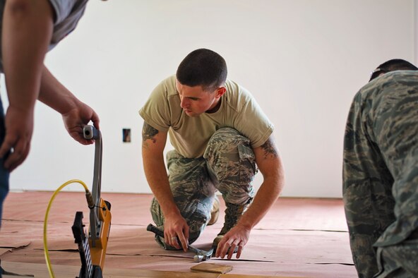 Senior Airman Joshua Harding, from the 512th Civil Engineer Squadron, makes sure the flooring pieces line up correctly at the Habitat for Humanity house in downtown Dover, Del., May 22, 2016. The house build is able to satisfy certain training requirements needed for 512th CE Airmen while also providing a real-world benifit to families in the local community. (U.S. Air Force photo/Capt. Bernie Kale)