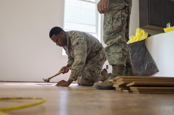 Senior Airman Scott Rector, 512th Civil Engineer Squadron, taps in flooring at a Habitat for Humanity build downtown Dover, Del., May 22, 2016, alongside the nonprofit Habitat for Humanity to provide housing forindividuals and families in need. The house build is able to satisfy certain training requirements needed for 512th CE Airmen while also providing a real-world benifit to families in the local community. (U.S. Air Force photo/Capt. Bernie Kale)