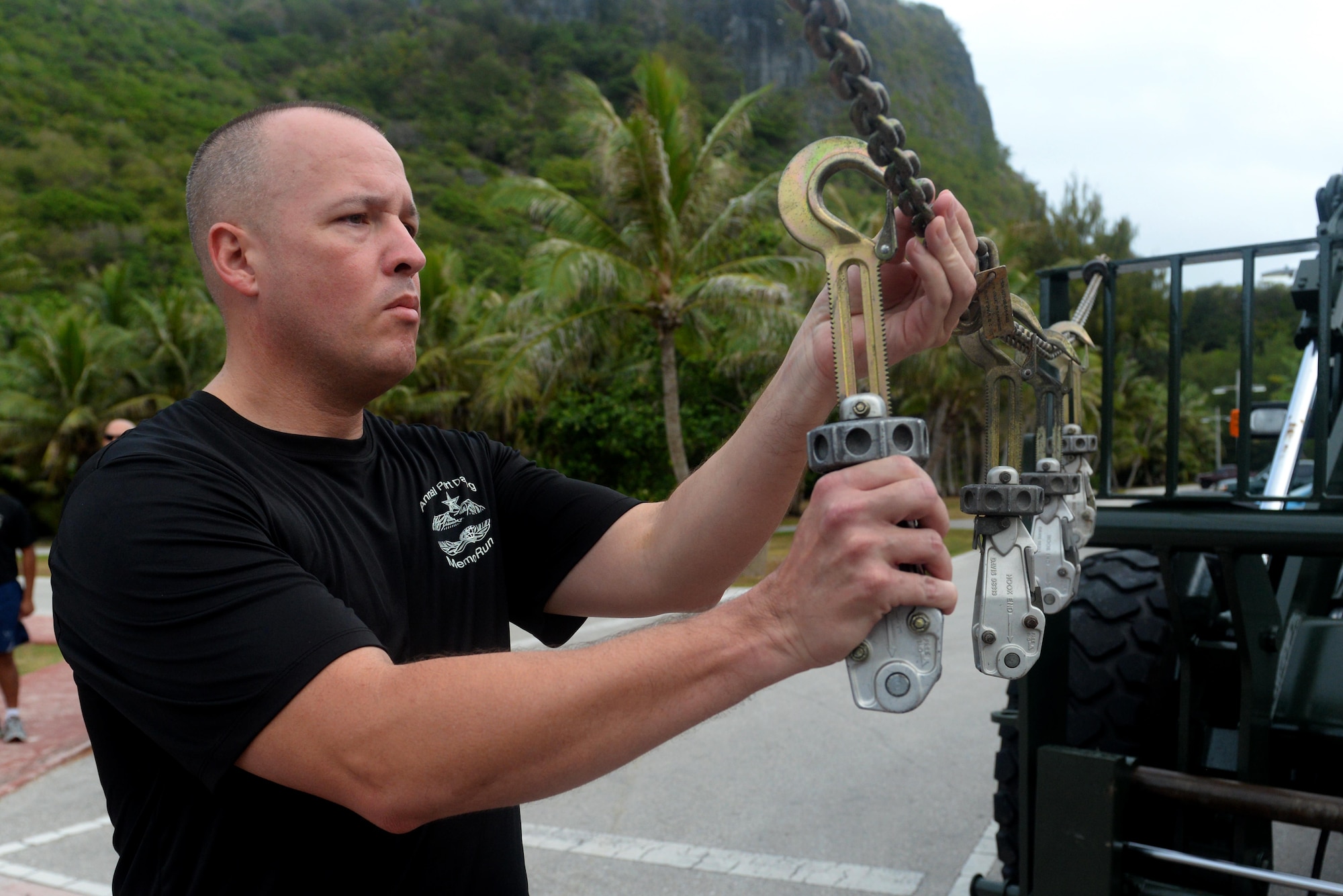 Chief Master Sgt. Travis Owen, 734th Air Mobility Squadron aerial port superintendent, hangs up MB-1 devices on a chain to commemorate fallen air transportation specialists May 20, 2016, at Andersen Air Force Base, Guam. Aerial porters, commonly referred to as Port Dawgs, are responsible for military logistics related to aerial ports and come from multiple units on Andersen to include the 734th AMS, 36th Contingency Response Group and 36th Mission Readiness Squadron. (U.S. Air Force photo by Airman 1st Class Alexa Ann Henderson)