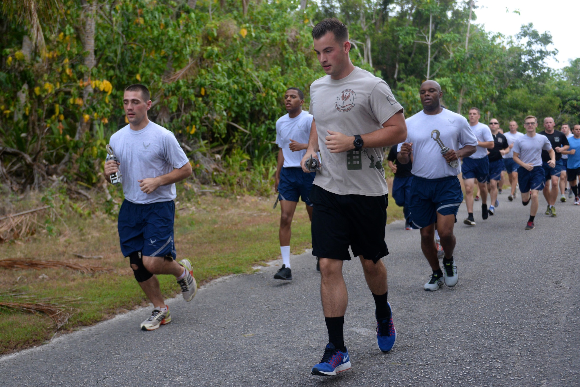 Air transportation specialists, commonly referred to as Port Dawgs, run with MB-1 devices during the Port Dawg memorial run May 20, 2016, at Andersen Air Force Base, Guam. The devices symbolize the five Port Dawgs who lost their lives in 2015. (U.S. Air Force photo by Airman 1st Class Alexa Ann Henderson)