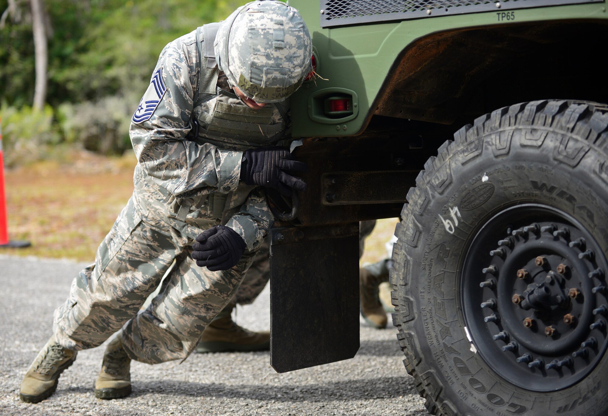 Chief Master Sgt. Aaron Sanchez, 36th Mission Support Group superintendent and his teammates push a Humvee up an incline during the Police Week Defender Challenge May 18, 2016, at Andersen Air Force Base, Guam. In honor of Police Week, the 36th SFS hosted the Defender Challenge, pitting Airmen against a variety of obstacles and navigational tasks. (U.S. Air Force photo by Senior Airman Joshua Smoot)