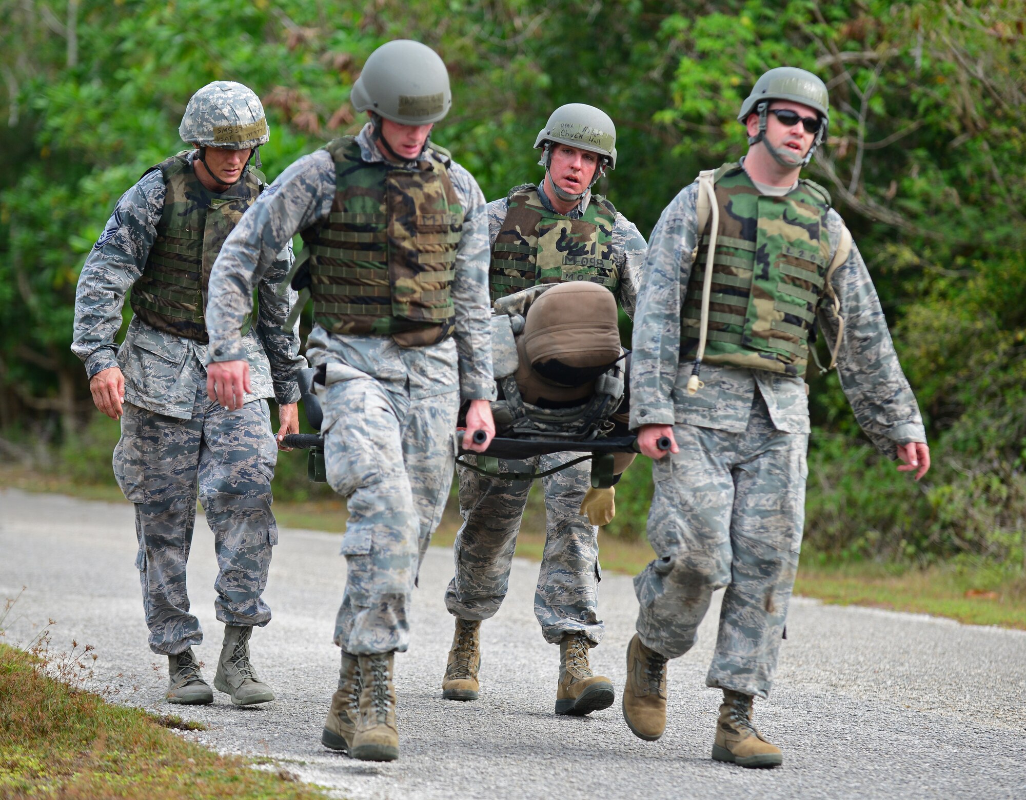 Members from the 36th Operations Support Squadron carry a simulated patient on a litter during the Police Week Defender Challenge May 18, 2016, at Andersen Air Force Base, Guam. In honor of Police Week, the 36th SFS hosted the Defender Challenge, pitting Airmen against a variety of obstacles and navigational tasks. (U.S. Air Force photo by Senior Airman Joshua Smoot)