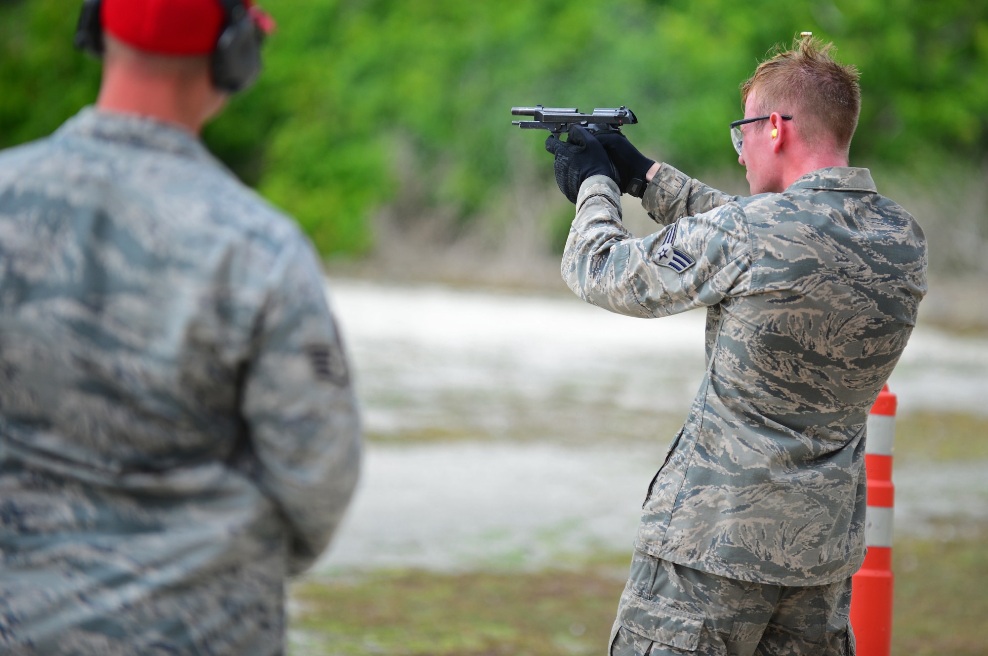 A Police Week Defender Challenge participant fires an M9 pistol May 18, 2016, at Andersen Air Force Base, Guam. To get people motivated for Police Week, the 36th SFS hosted the Defender Challenge, pitting Airmen against a variety of obstacles and navigational tasks. (U.S. Air Force photo by Senior Airman Joshua Smoot)