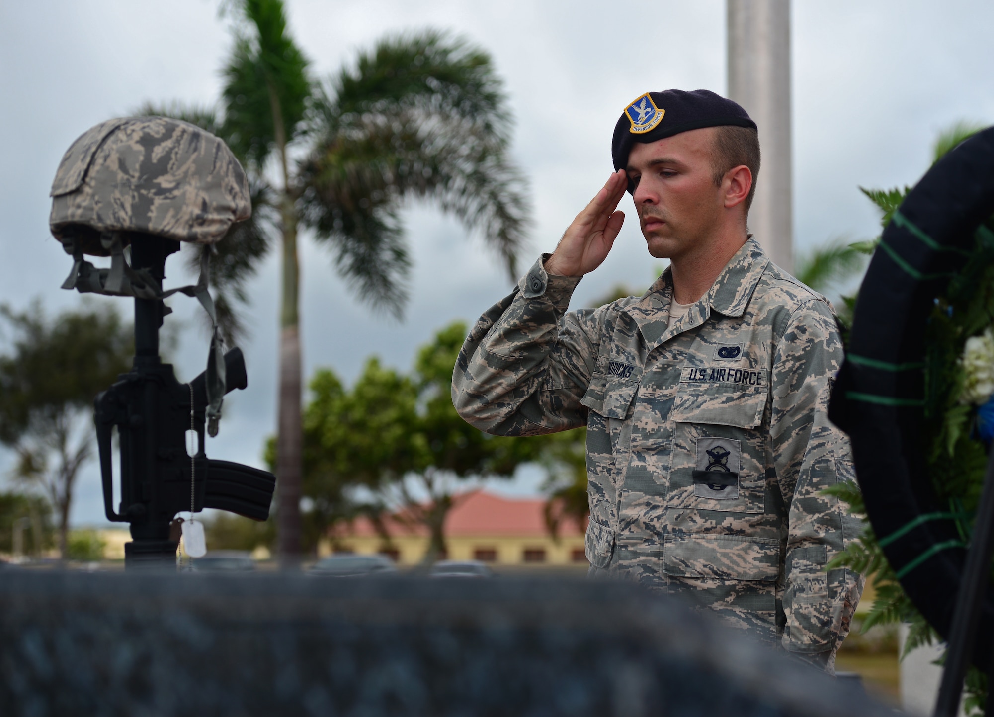 Senior Airman Steven Hendricks, 36th Security Forces Squadron member, salutes a fallen warrior memorial May 20, 2016, at Andersen Air Force Base, Guam. The symbolic battle cross is composed of a replica M4 carbine with a helmet at the top and boots in front. Additionally, 10 dog tags hang from the rifle detailing fallen Airmen and the name of the operation they supported. The vigil was held in honor of fallen security forces members on the occasion of Police Week. (U.S. Air Force photo by Senior Airman Joshua Smoot)
