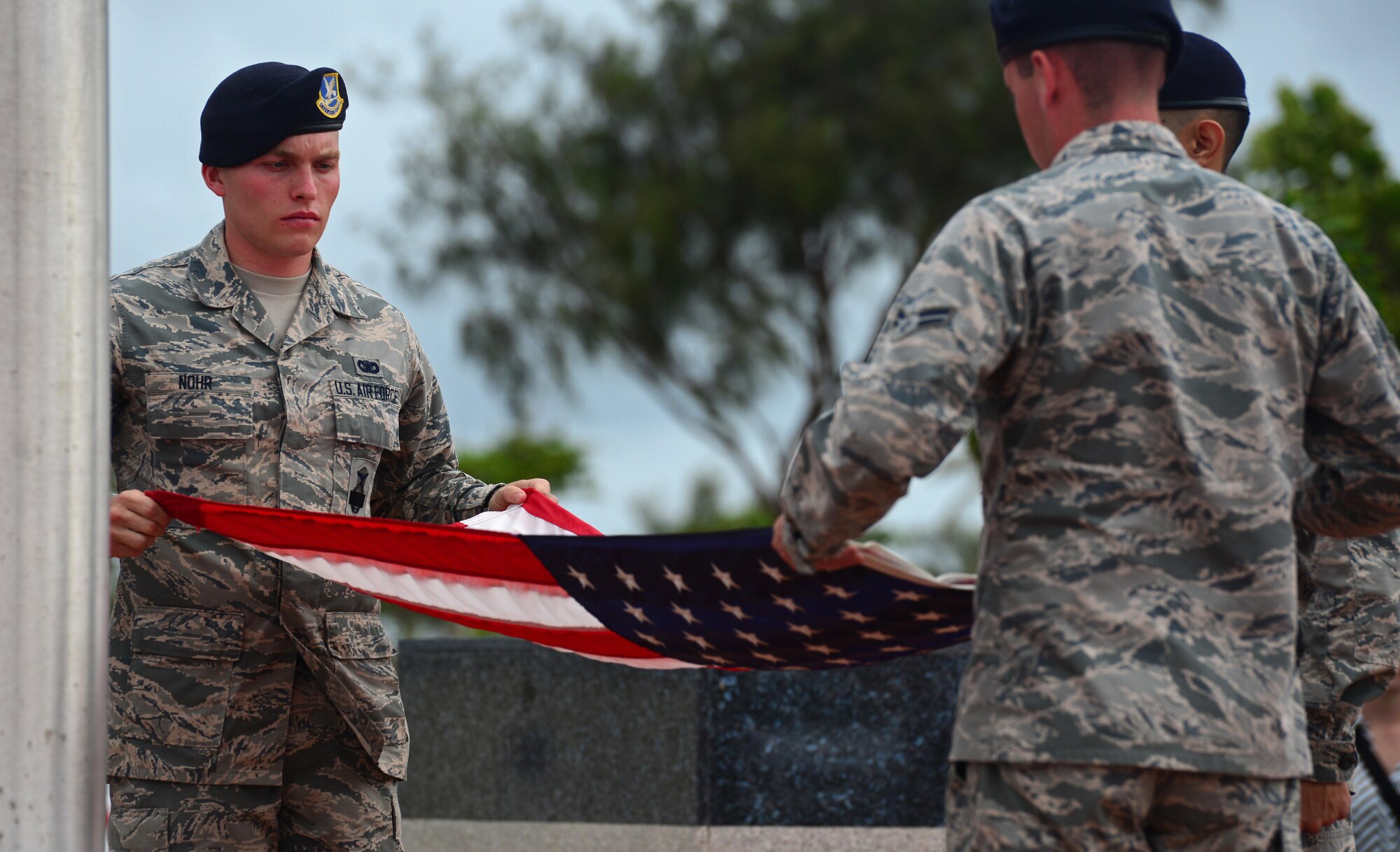 Airmen from the 36th Security Forces Squadron fold the American flag during a retreat ceremony May 20, 2016, at Andersen Air Force Base, Guam. The ceremony was one of several events during Police Week in which Andersen Airmen honored their fallen wingmen. (U.S. Air Force photo by Senior Airman Joshua Smoot)