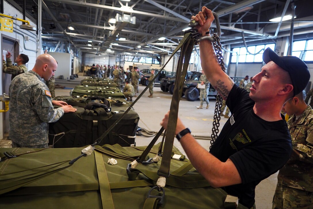 Army Sgt. 1st Class Ronald Burgess, right, helps train students in slingload operations at Joint Base Elmendorf-Richardson, Alaska, May 18, 2016. Burgess is an instructor assigned to the U.S. Army Pathfinder School. Air Force photo by Justin Connaher