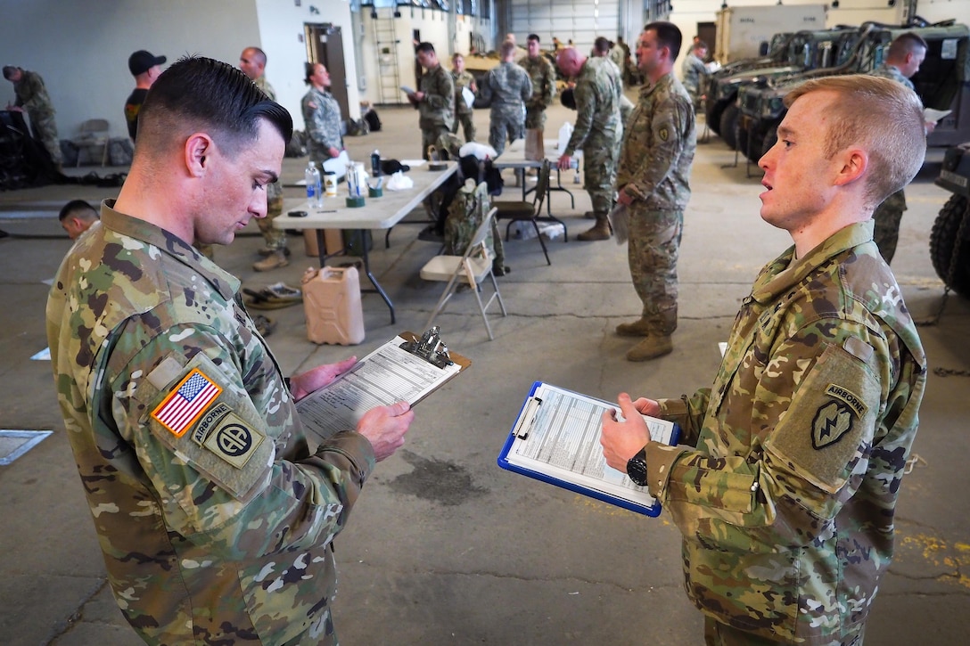 Army Staff Sgt. William Moore, left, and 1st Lt. Andrew Nelden discuss tasks at hand while participating in slingload operations training under U.S. Army Pathfinder School instructors at Joint Base Elmendorf-Richardson, Alaska, May 18, 2016. Moore and Nelden are assigned to the 25th Infantry Division’s Company B, 725th Brigade Support Battalion, 4th Infantry Brigade Combat Team (Airborne). Air Force photo by Justin Connaher