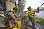 Wyoming Army National Guard Sgt. Jordan McDonald, of Evanston, and Spc. Miura Yuki, of Laramie, fill sandbags on the bank along the North Platte River in Saratoga,Wyoming, on May 20. Gov. Matt Mead activated more than 70 members of the Wyoming National Guard to assist local emergency management officials with flood prevention and mitigation efforts in light of rising spring temperatures. 