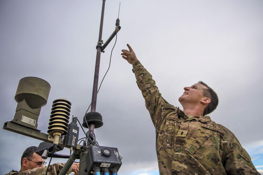 Air Force 1st Lt. Justin D'olimpio points to part of a tactical meteorological observation system during routine maintenance at Bagram Airfield, Afghanistan, May 16, 2016. D'olimpio is weather flight commander of the 455th Expeditionary Operations Support Squadron. Air Force photo by Senior Airman Justyn M. Freeman