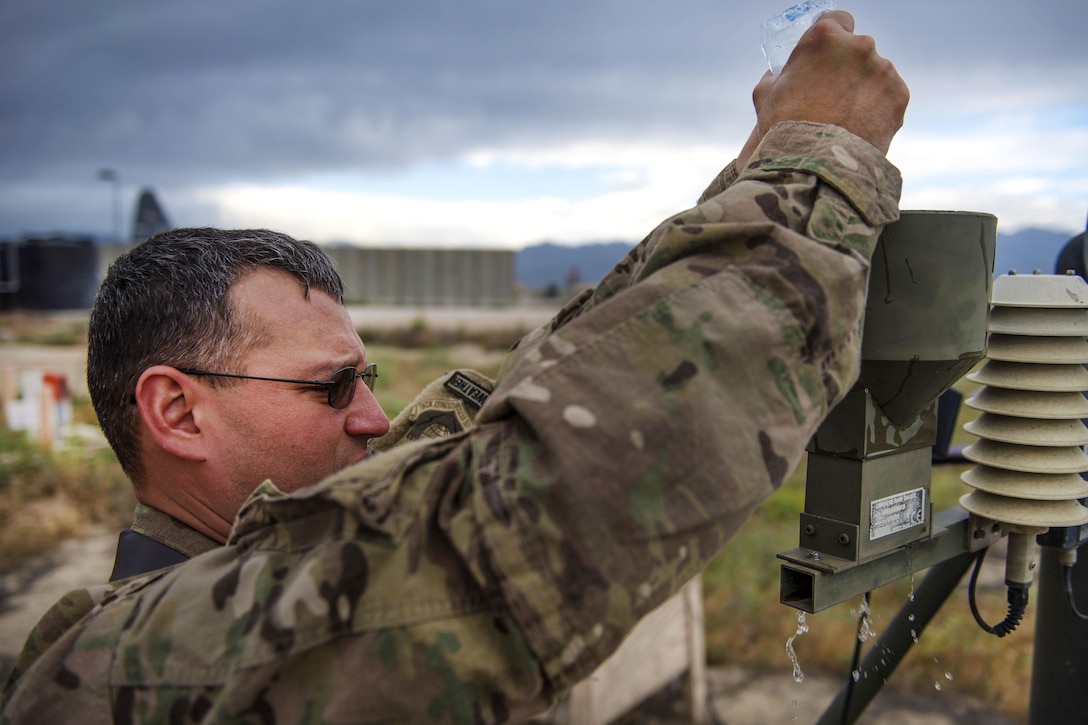 Air Force Tech. Sgt. Heinz Disch cleans the precipitation catcher on a tactical meteorological observation system at Bagram Airfield, Afghanistan, May 16, 2016. Disch is a weather forecaster assigned to the 455th Expeditionary Operations Support Squadron. Air Force photo by Senior Airman Justyn M. Freeman
