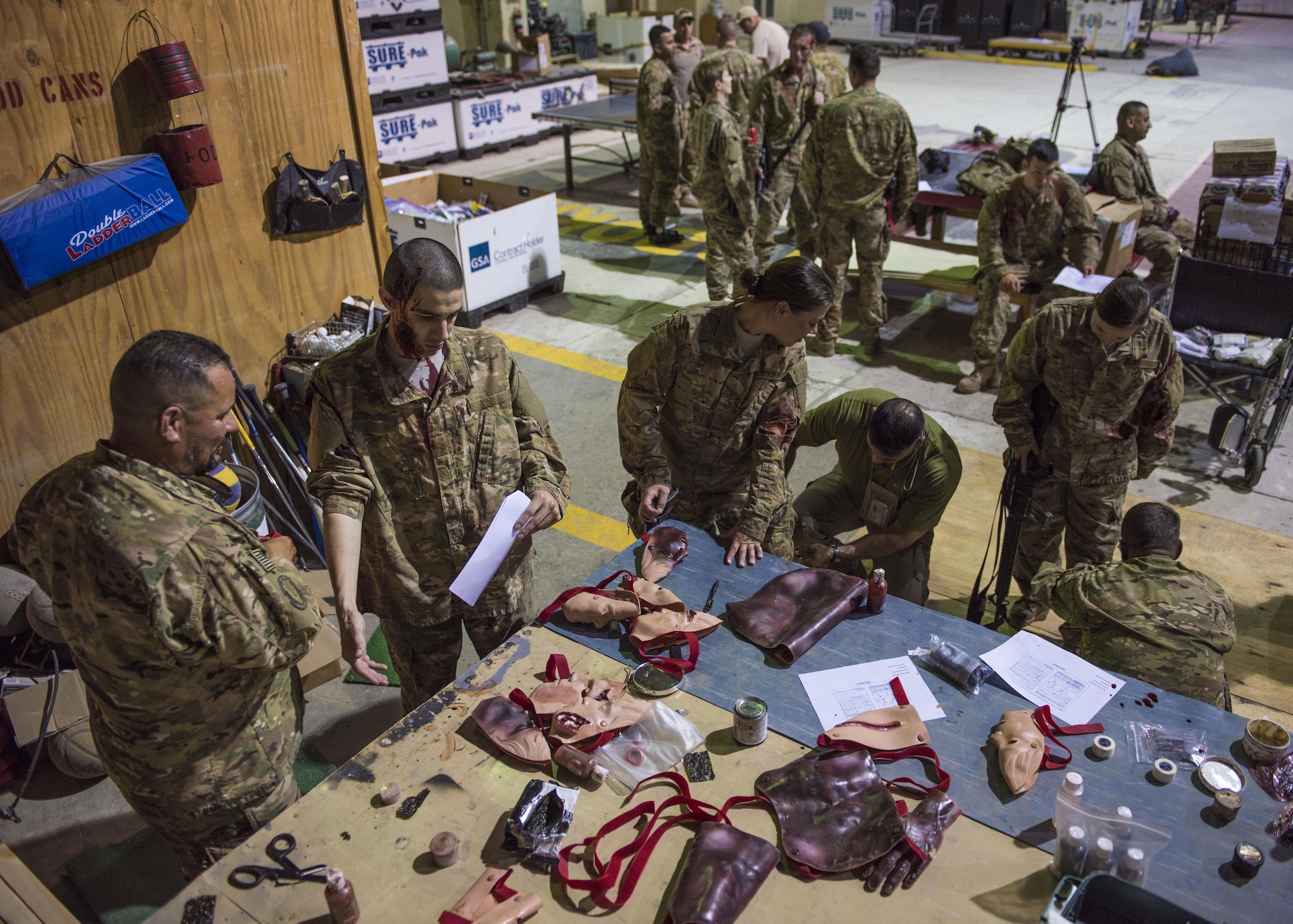 Department of Defense civilians apply medical moulage to volunteers for the mass casualty exercise held by the 455th Expeditionary Medical Group, at Bagram Airfield, Afghanistan, May 21, 2016. The application of moulage to Airmen provides a sense of realism in exercises that medics and first responders may encounter in real-world accidents. (U.S. Air Force photo by Senior Airman Justyn M. Freeman)
