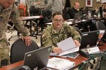 Army Spc. Robin Hefner, a human resource specialist assigned to U.S. Army North, goes over Vibrant Response 16 battle plans with another Tactical Operations Center soldier at Camp Atterbury, Indiana, May 3, 2016. VR 16 is led by ARNORTH and brings military, federal, and state agencies together to train to respond to a national emergency.