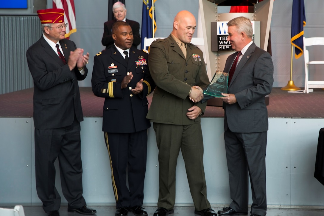 Capt. Samuel L. Baumer (second from right), adjutant for Marine Aircraft Group 41, 4th Marine Aircraft Wing, Marine Forces Reserve, is presented the Mayor’s Military Advisory Committee Community Service award by retired Marine Maj. Gen. David M. Mize (right), chairman of the Mayor’s Military Advisory Committee, during the Armed Forces Day celebration at the National World War II Museum, May 21, 2016. Baumer was recognized for his outstanding efforts in improving the local community and for setting an excellent example to his fellow Marines. Marine Forces Reserve operates from 160 locations across the U.S. allowing the Marines the unique opportunity to connect with the communities in which they live. (U.S. Marine Corps photo by Lance Cpl. Melissa Martens/ Released) 