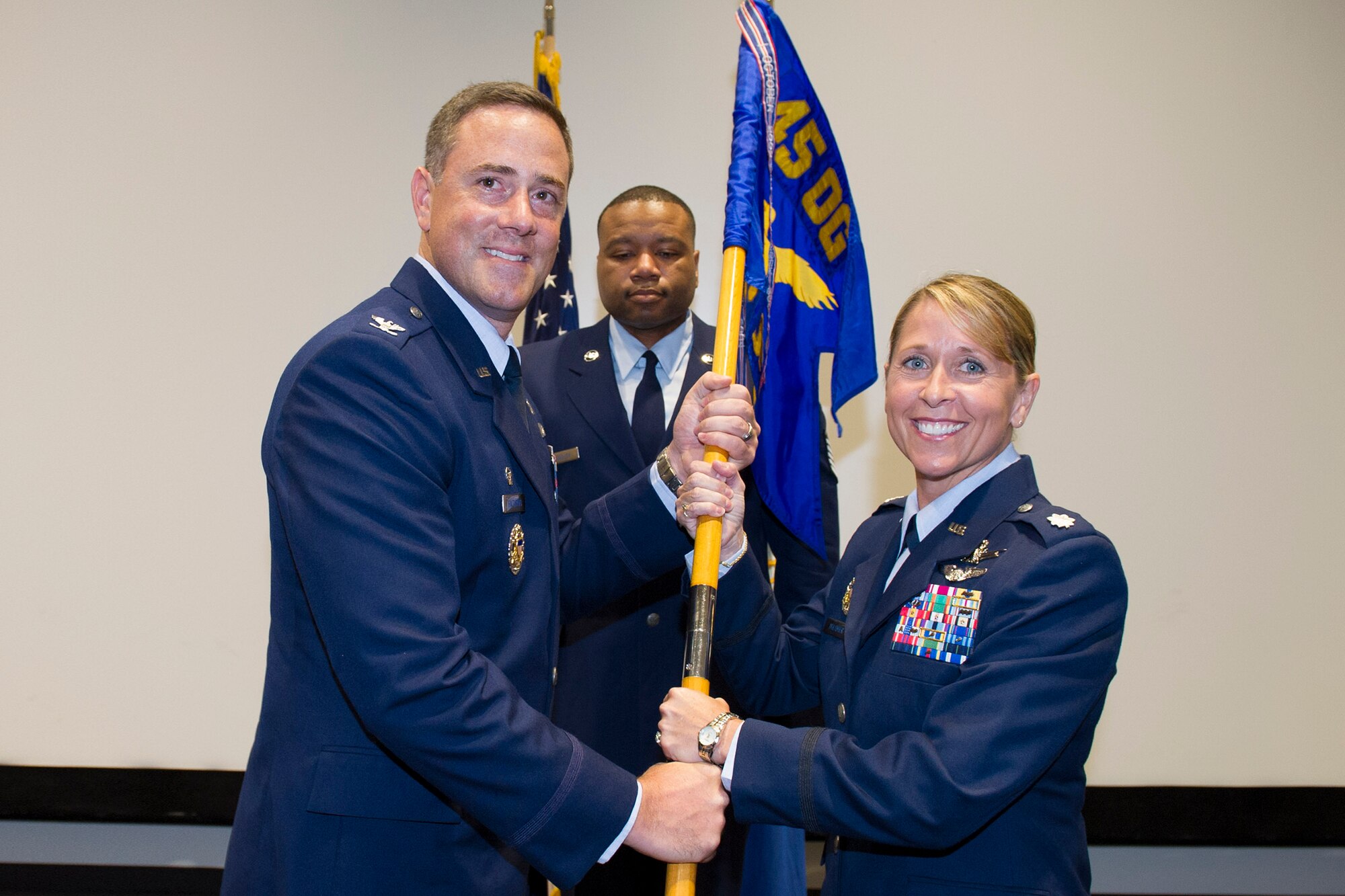 Col. Thomas Falzarano, 45th Operations Group commander, presents Lt. Col. Monique Delauter, 1st Range Operations Squadron commander, with the 1st ROPS guidon during a change of command ceremony May 20, 2016, at the Cape Canaveral Air Force Station Morrell Operations Center, Fla. Changes of command are a military tradition representing the transfer of responsibilities from the presiding officials to the upcoming official. (U.S. Air Force photo/Matthew Jurgens/Released) 