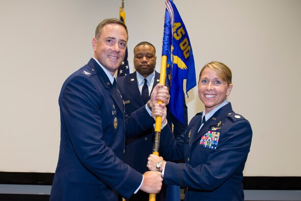 Col. Thomas Falzarano, 45th Operations Group commander, presents Lt. Col. Monique Delauter, 1st Range Operations Squadron commander, with the 1st ROPS guidon during a change of command ceremony May 20, 2016, at the Cape Canaveral Air Force Station Morrell Operations Center, Fla. Changes of command are a military tradition representing the transfer of responsibilities from the presiding officials to the upcoming official. (U.S. Air Force photo/Matthew Jurgens/Released) 