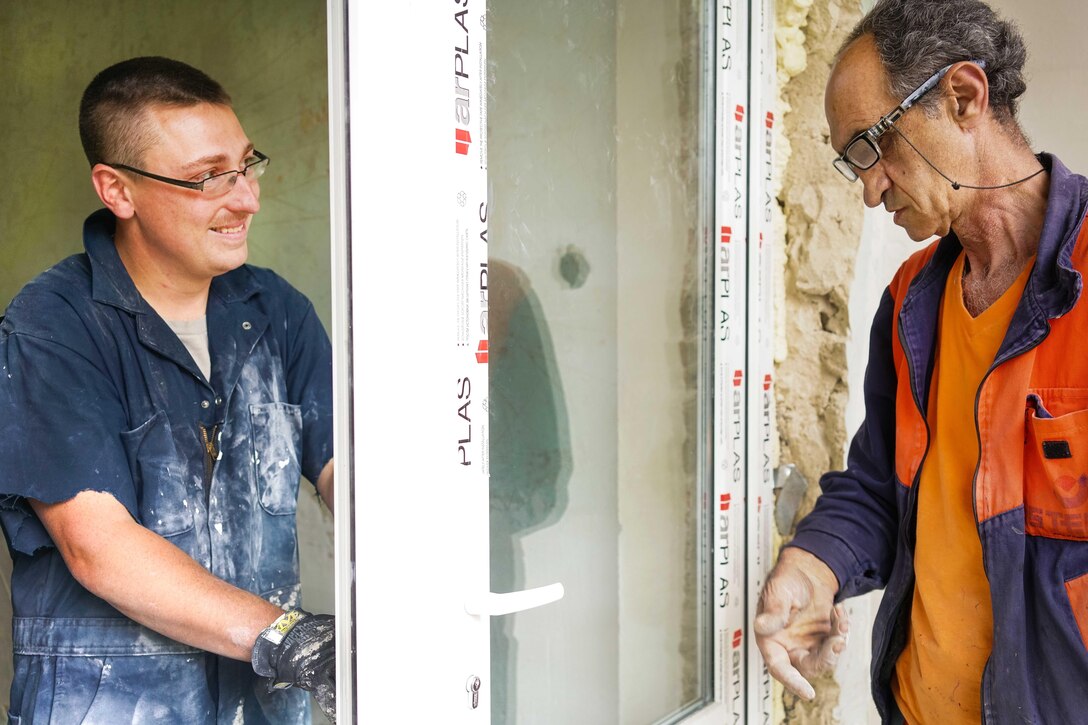 Air Force Staff Sgt. Aaron Nickell, left, installs a door with an Armenian contractor at a care facility for the elderly during a U.S. European Command humanitarian civic assistance project in Yerevan, Armenia, May 13, 2016. Nickell is a structures craftsman assigned to the 461st Air Control Wing. Air National Guard photo by Senior Master Sgt. Roger Parsons 