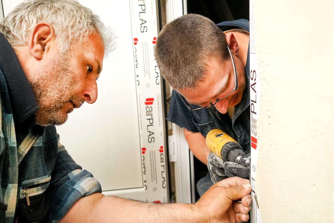 Air Force Staff Sgt. Aaron Nickell, right, and an Armenian contractor install a bathroom door at a care facility for the elderly during a U.S. European Command humanitarian project in Yerevan, Armenia, May 13, 2016. Nickell is a structures craftsman assigned to the 461st Air Control Wing. Air National Guard photo by Senior Master Sgt. Roger Parsons