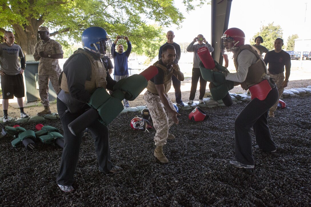Collegiate coaches train with pugil sticks during the Marine Corps Martial Arts Program iteration of the 2016 Marine Corps Recruiting Command Coaches Workshop at the Martial Arts Center of Excellence aboard Marine Corps Base Quantico, Va., May 20, 2016. Coaches learned how MCMAP fighting skills are used by Marines during close-range encounters with an enemy and how they contribute to the mental and physical development of Marines.