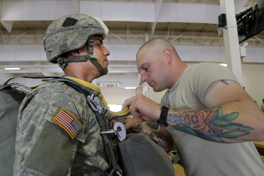 Army Sgt. 1st Class Brandon Ryan, right, inspects Army Spc. Carlos Moscoso’s parachute rigging before joint airborne and air transportability training at Joint Base Elmendorf-Richardson, Alaska, May 19, 2016. Ryan, a jumpmaster, and Moscoso are assigned to the 25th Infantry Division’s 1st Battalion, 501st Parachute Infantry Regiment, 4th Infantry Brigade Combat Team (Airborne). Air Force photo by Alejandro Pena