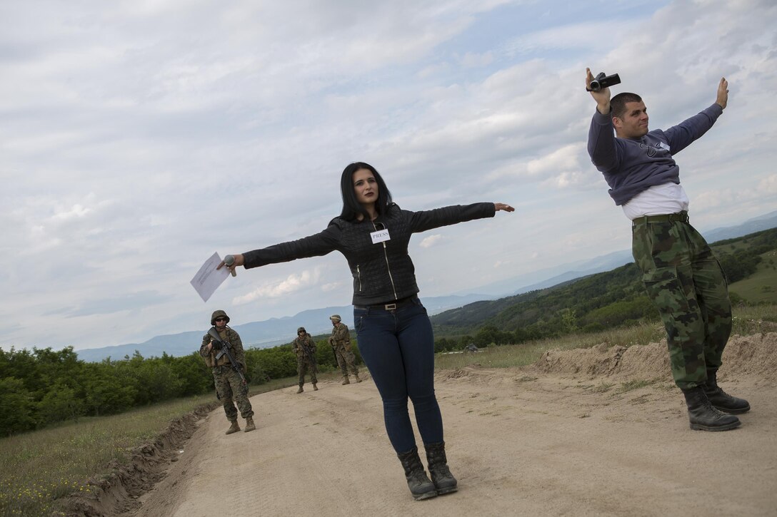 As part of a simulated peacekeeping operation, Reserve Marines with 4th Law Enforcement Battalion, Force Headquarters Group, Marine Forces Reserve, ask approaching civilians to stop while they patrol down a road during exercise Platinum Wolf 2016 at Peacekeeping Operations Training Center South Base, Bujanovac, Serbia, May 19, 2016. The Marines are working with the partner nations of Bosnia, Bulgaria, Macedonia, Montenegro, Slovenia and Serbia during the final field exercise. During the field exercise the Marines complete various training scenarios along their patrol route, including being approached by service members with the Serbian Armed Forces simulating interaction with civilian press.