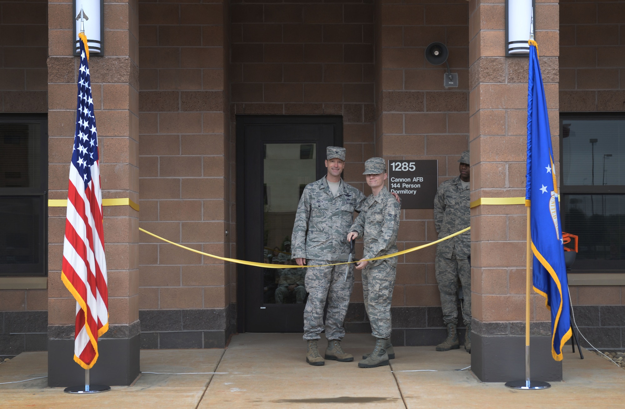 Col. Matthew Smith, 27th Special Operations Wing vice commander, and Airman 1st Class Tyler Nowling, 27th Special Operations Support Squadron air traffic controller, cut the ribbon on a new dorm facility May 18, 2016, at Cannon Air Force Base, N.M. This $20.5 million project began in August 2014 and what completed 175 days prior to the original expected completion date; which is great news for current residents scheduled to occupy the new dorm as this facility will effectively end double-occupancy for the wing. (U.S. Air Force photo/Staff Sgt. Alexx Pons)