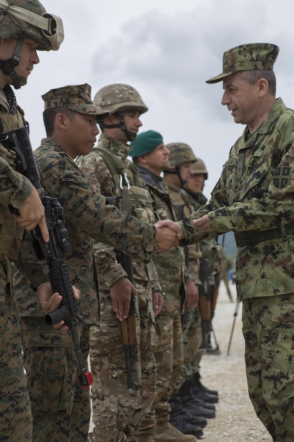 Sgt. Steven Amnatkeolee, assistant platoon sergeant with, 4th Law Enforcement Battalion, Force Headquarters Group, Marine Forces Reserve, receives a coin from Lt. Gen. Jovica Draganic, Deputy Chief of Staff of the Army of Serbia, in recognition of his hard work and efforts during exercise Platinum Wolf 2016 at Peacekeeping Operations Training Center South Base, Bujanovac, Serbia, May 20, 2016. The nations of Bosnia, Bulgaria, Macedonia, Montenegro, Slovenia, Serbia and the United States joined together during the final field exercises to demonstrate their abilities to conduct peacekeeping operations and the ability to work together.