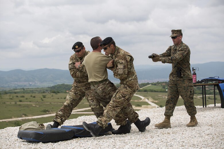 1st Lt. Jonathan Stinson, (far right) platoon commander with Company Delta, 4th Law Enforcement Battalion, Force Headquarters Group, Marine Forces Reserve, demonstrates the use of a Taser during Distinguished Visitors Day of exercise Platinum Wolf 2016 at Peacekeeping Operations Training Center South Base, Bujanovac, Serbia, May 20, 2016. The nations of Bosnia, Bulgaria, Macedonia, Montenegro, Slovenia, Serbia and the United States join together during the final field exercises to demonstrate their abilities to conduct peacekeeping operations and the ability to work together.