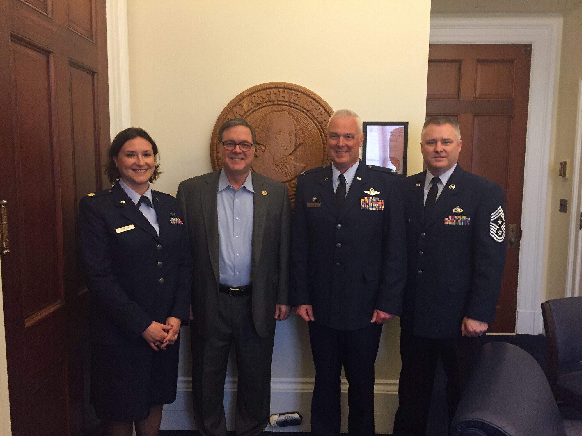 (From left to right) Maj. Brooke Cortez, left, 446th Airlift Wing public affairs officer, Rep. Denny Heck, Col. Scott McLaughlin, 446th AW wing commander, and Chief Master Sgt. Anthony L. Mack, 446th AW command chief master sergeant, pose for a photograph in Washington, D.C., recently.