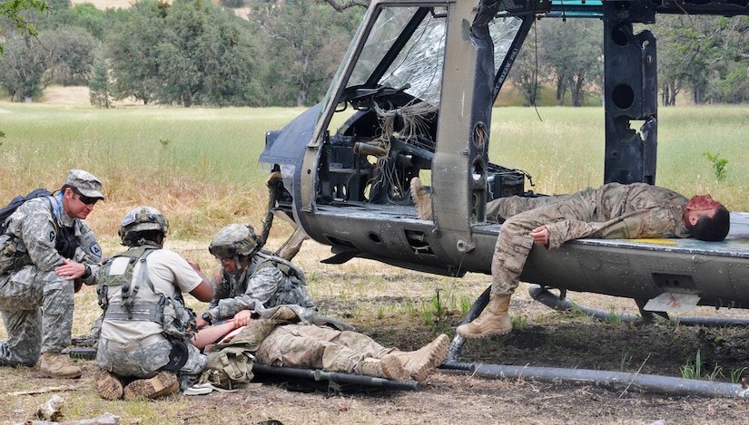 JOLON, Calif. – Sgt. 1st Class James Wardle (right) and Spc. Jacob Duncan (laying left), both Opposing Forces casualties with the 570th Sapper Company, 864th Engineer Battalion, 555th Engineer Brigade of Joint Base Lewis-McChord, Wash., simulate casualties of a helicopter crash during a route-clearance and medical training exercise at Fort Hunter Liggett, Calif., May 6. (U.S. Army photo by Sgt. Kimberly Browne, 350th Public Affairs Detachment)