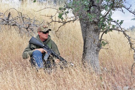 JOLON, Calif. – Spc. Robert Tolan, an Opposing Forces insurgent and cavalry scout with the 422nd Military Police Company, 11th MP Brigade, 200th MP Command, waits for the unit training before laying down harassing fire and creating a difficult environment for the training unit at Fort Hunter Liggett, Calif., May 6. (U.S. Army photo by Sgt. Kimberly Browne, 350th Public Affairs Detachment)