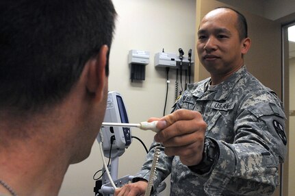 JOLON, Calif. - Spc. Phuong Nguyen, 7215th Medical Support Unit licensed practical nurse, checks the temperature of a patient at the Troop Medical Clinic at Fort Hunter Liggett, May 16. Nguyen's unit provided care to troops participating in various exercises May 9 to 20. (Photos by Staff Sgt. Lewis M. Hilburn, 350th Public Affairs Detachment, United States Army Reserve)